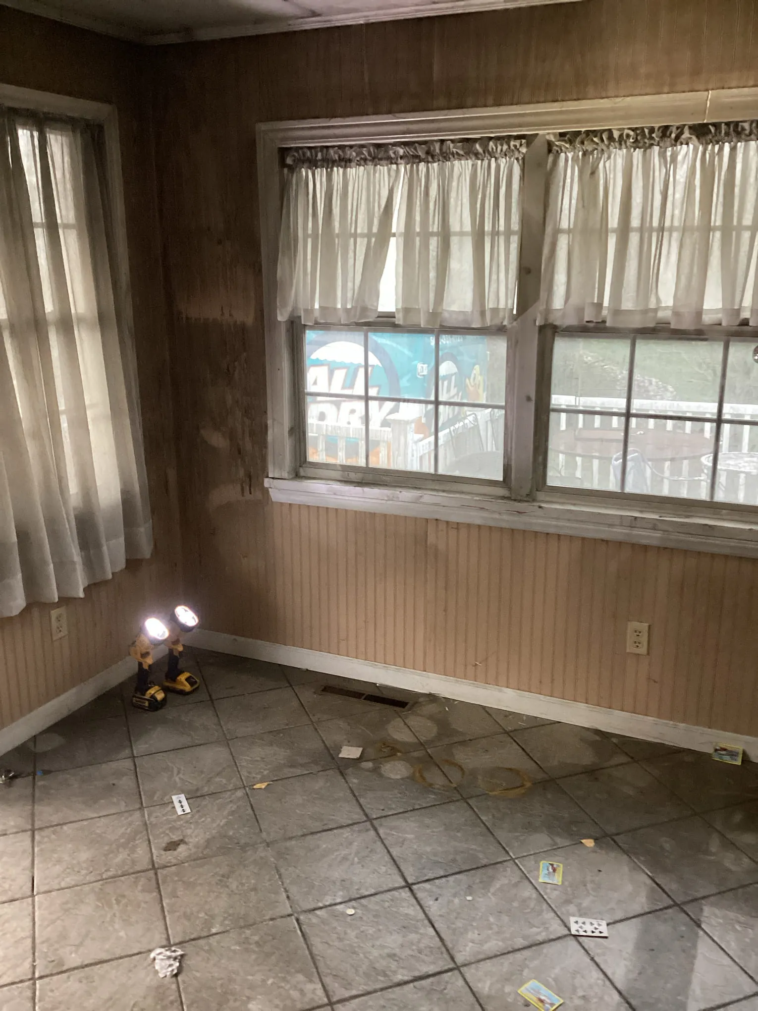 Smoke staining across the walls and floor of a room during an All Dry cleanup, the company van visible outside the window