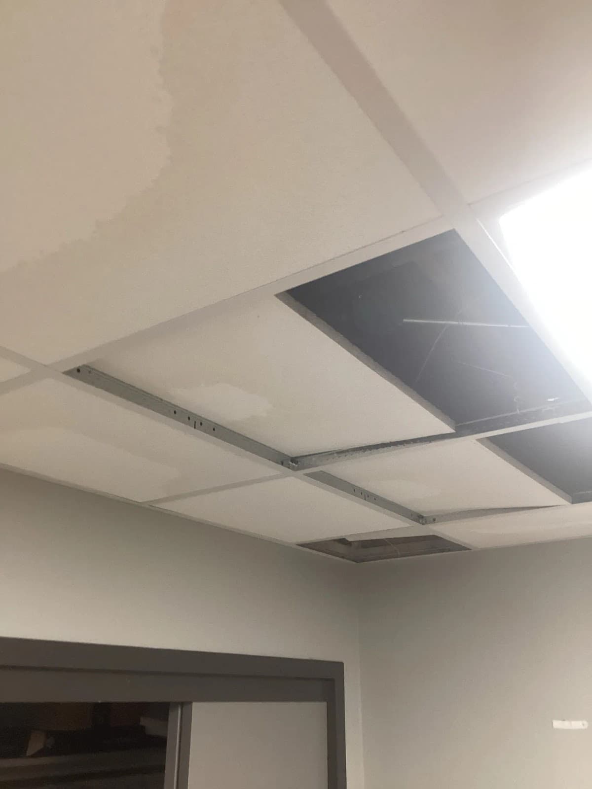 Drop ceiling with a stained tile lifted out during a Louisville inspection