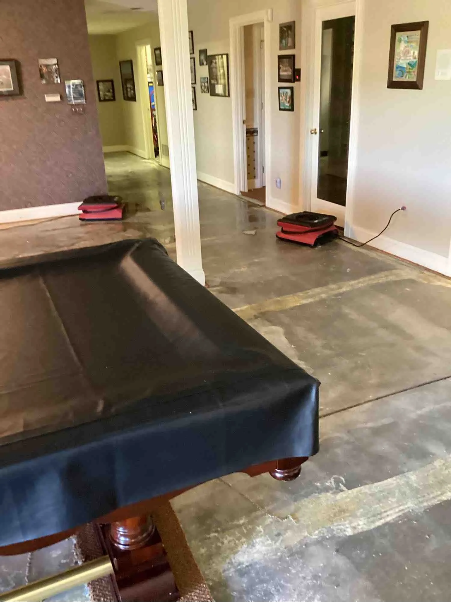 Finished basement with flooring removed and drying equipment running after a flood