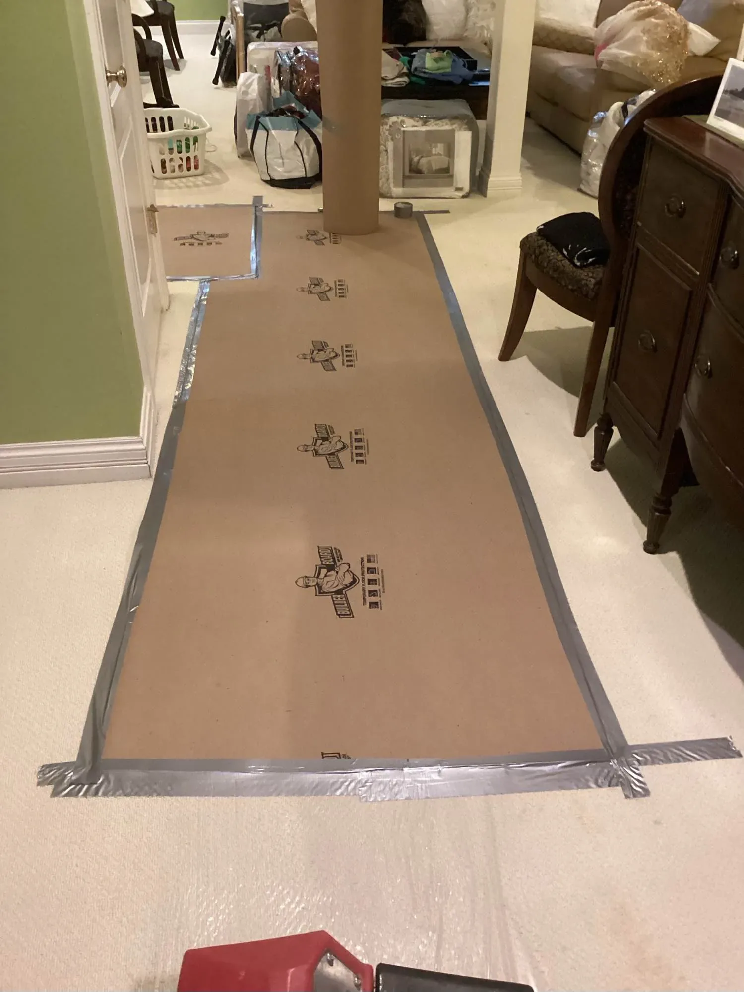 Protective covering taped down a hallway and contents moved aside during restoration work in an established home