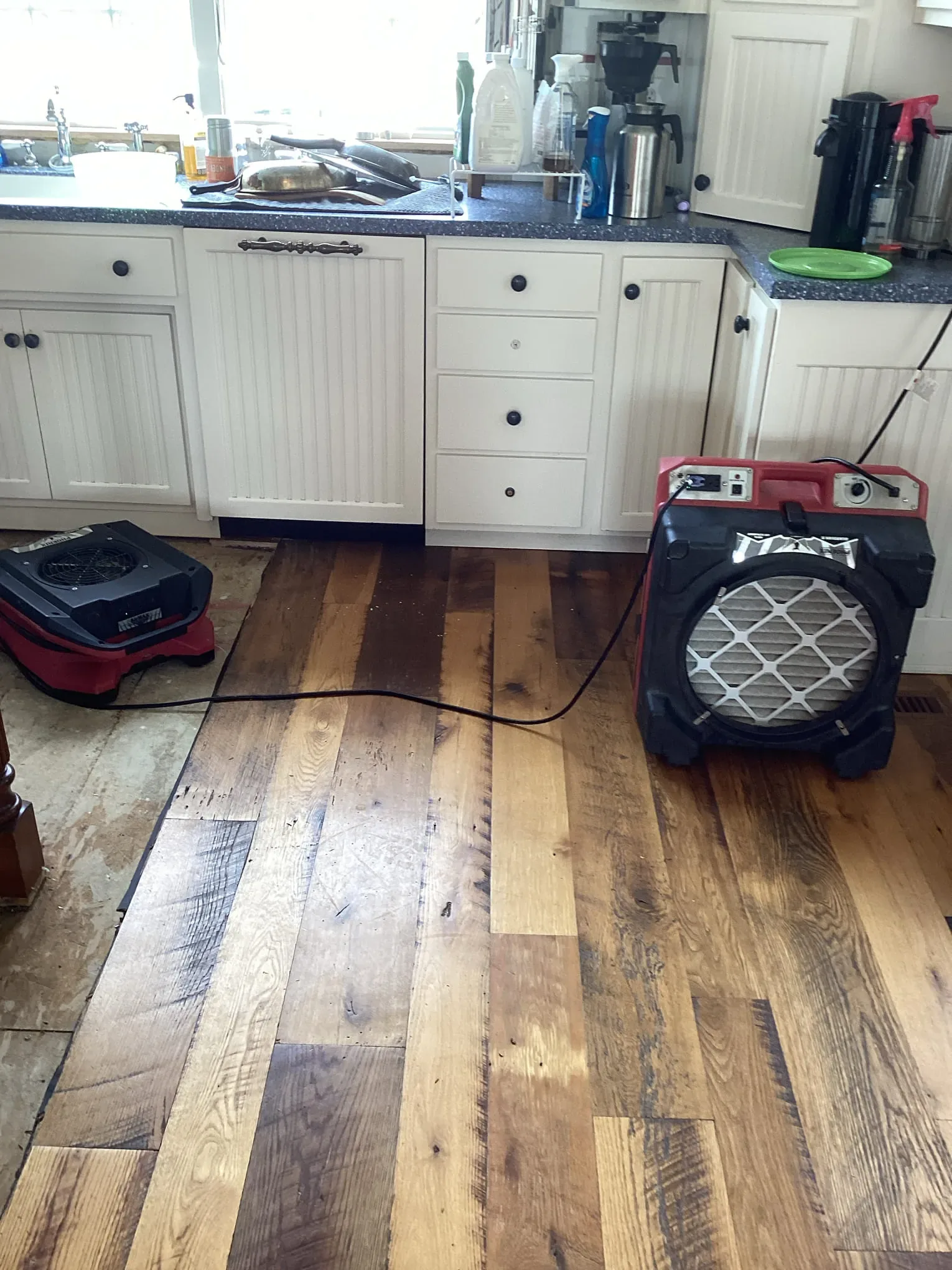 Commercial air mover drying a hardwood floor after a water intrusion
