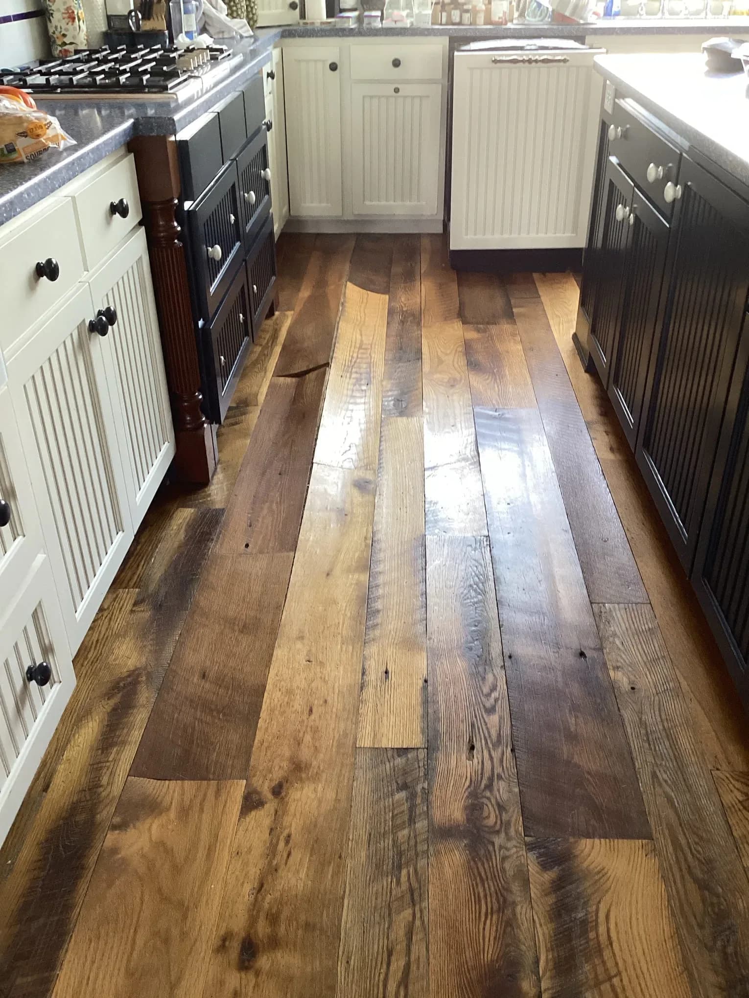 Water staining across a hardwood kitchen floor after a leak in a La Grange area home
