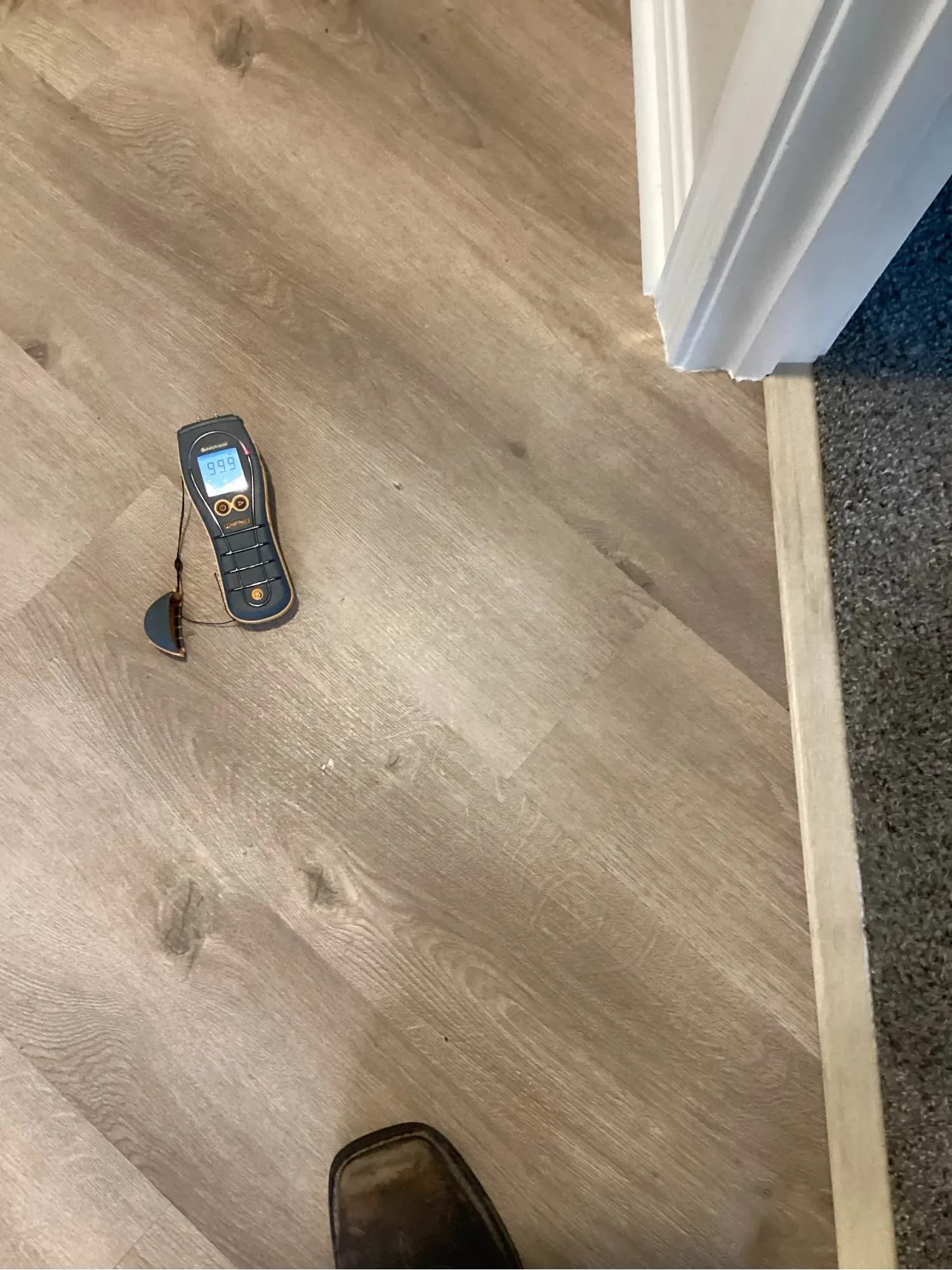 Moisture meter reading taken on laminate flooring during a water damage inspection