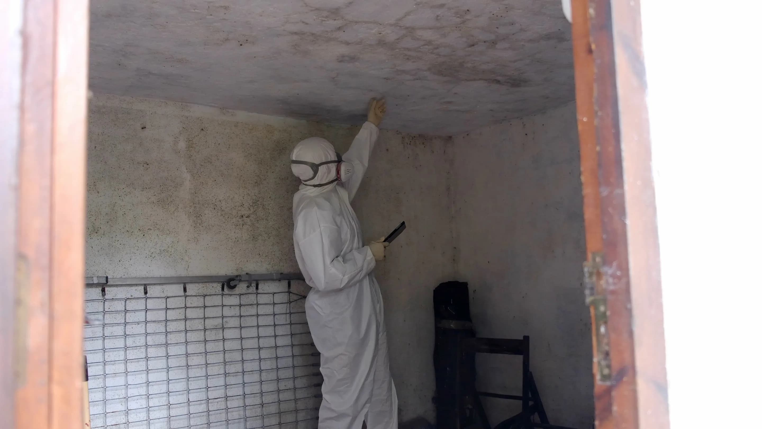 Technician in protective equipment working inside a sealed containment area in Louisville