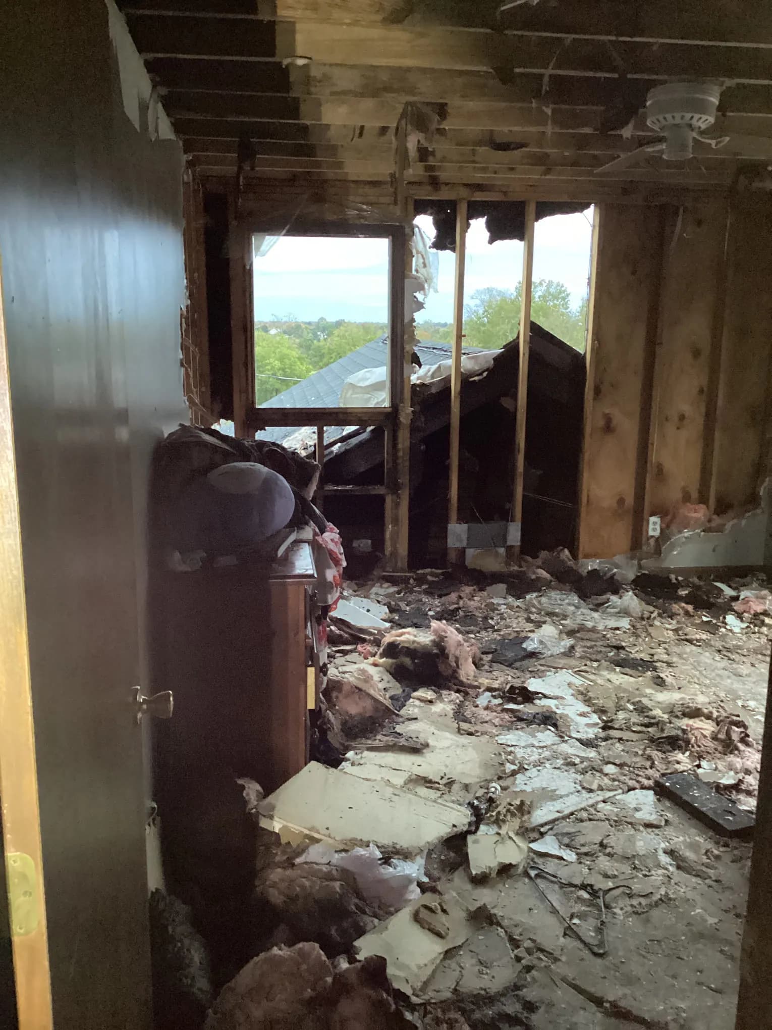 Room stripped back to the framing with debris across the floor after a major loss