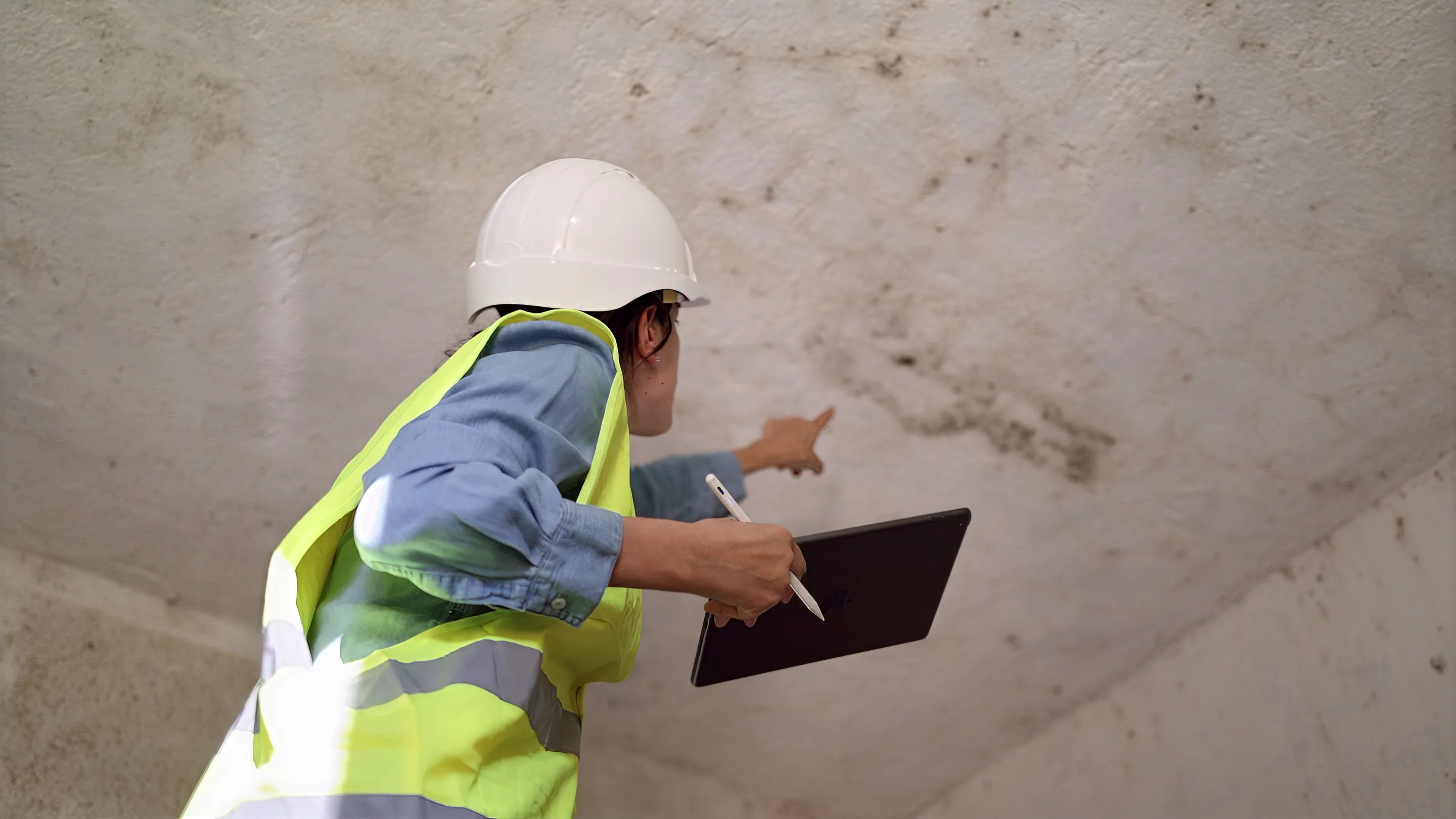 Technician documenting water damage on a wall for an insurance claim